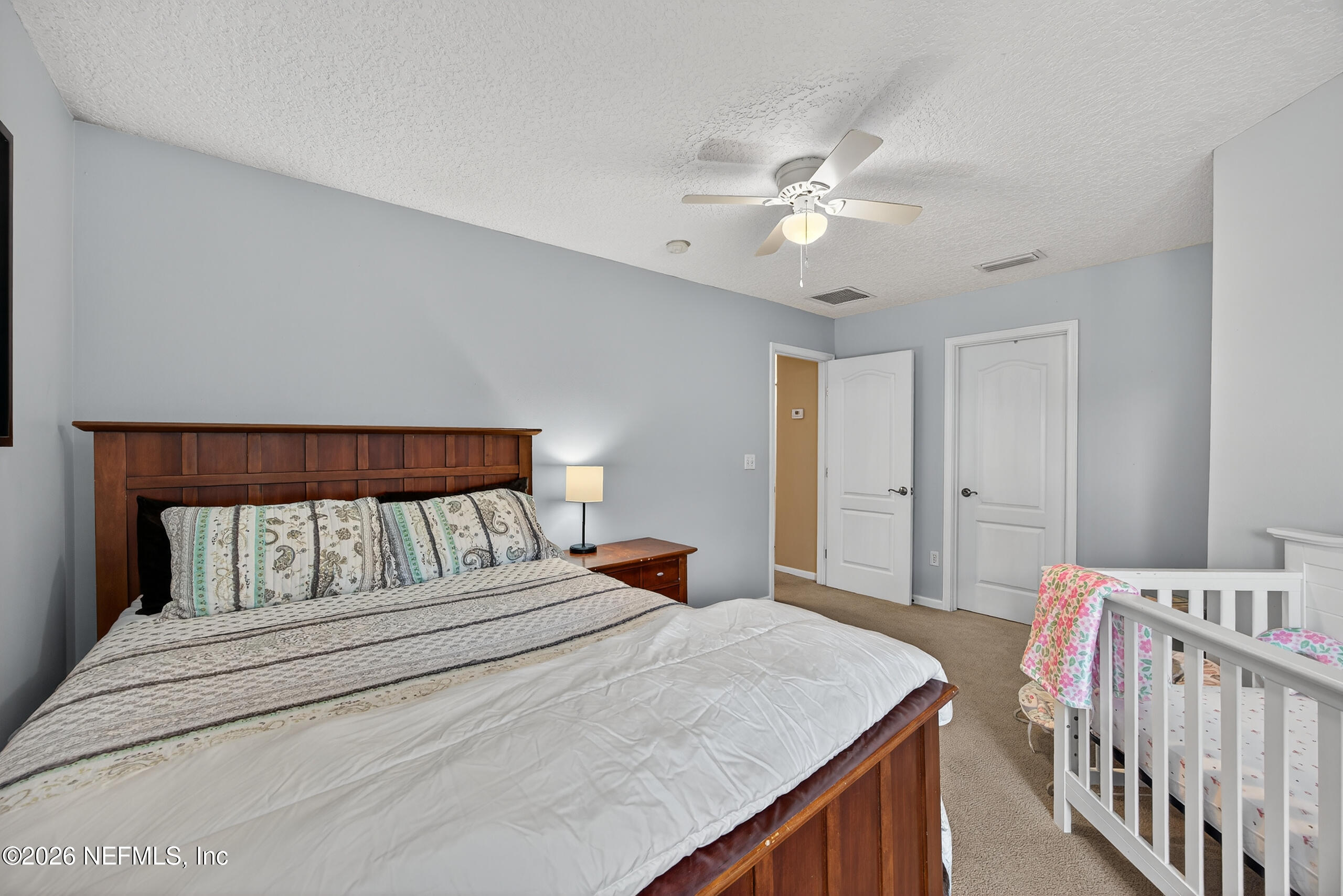 588 Reflection Cove Road Jacksonville, FL 32218 - Photo 28 of 53 a bedroom with a bed and a chandelier