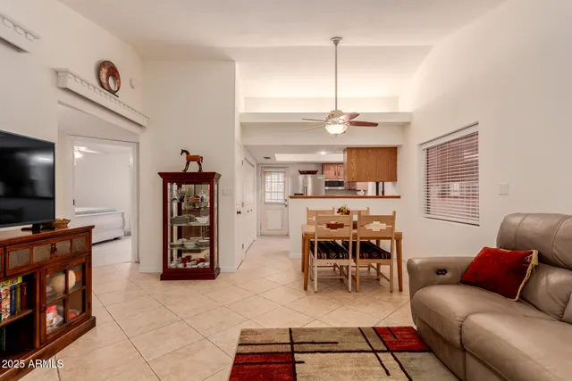 a living room with furniture a flat screen tv and kitchen view
