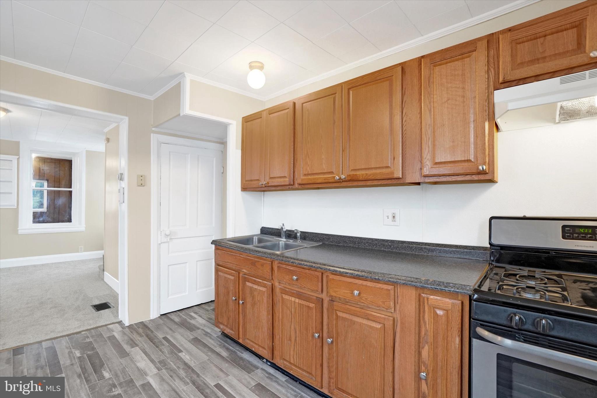 923 East Princess Street York, PA 17403 - Photo 11 of 24 a kitchen with granite countertop wooden cabinets and a stove top oven