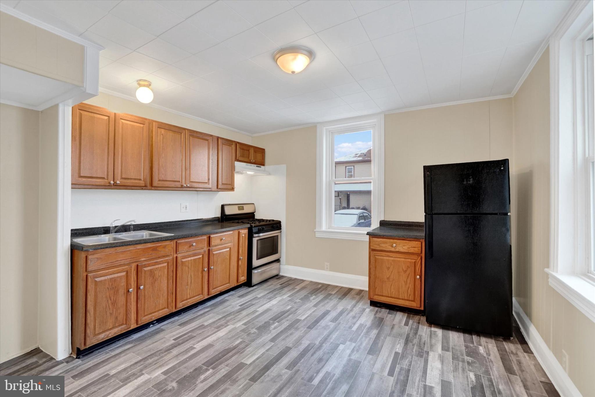 923 East Princess Street York, PA 17403 - Photo 9 of 24 a kitchen with granite countertop wooden floors and stainless steel appliances