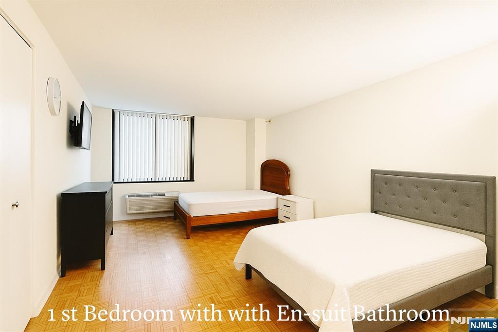 1265 15th Street, Unit 1A Fort Lee, NJ 07024 - Photo 9 of 14 a spacious bedroom with a bed and a flat screen tv