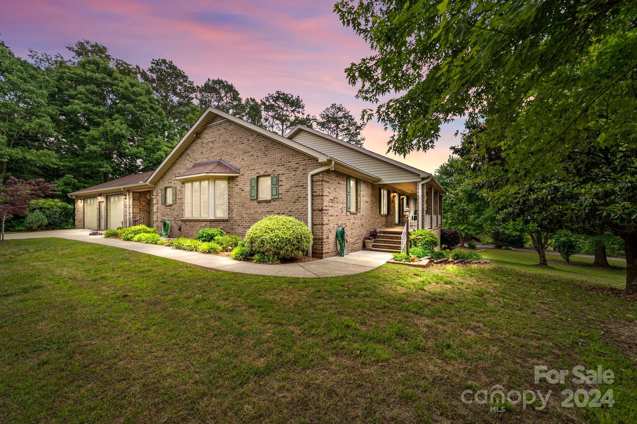 a view of a house with a big yard and palm trees
