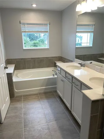 a bathroom with a tub sink and mirror