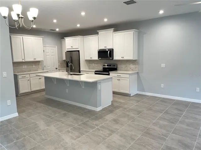 a kitchen with stainless steel appliances granite countertop a stove top oven a sink and a granite counter tops