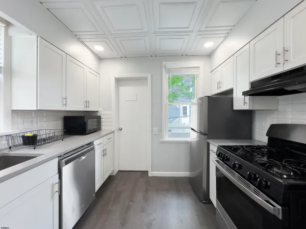 a kitchen with stainless steel appliances a sink a stove and cabinets