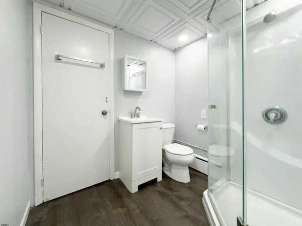 a bathroom with a granite countertop toilet a sink and a shower