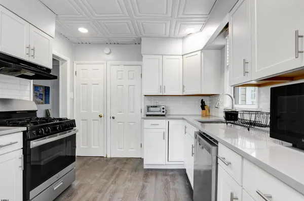 a kitchen with stainless steel appliances a sink dishwasher a stove and a refrigerator