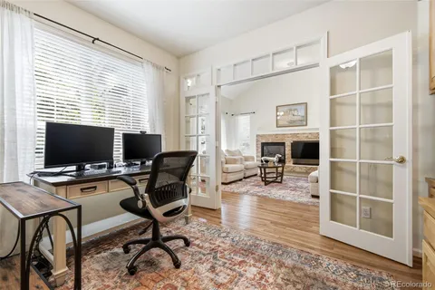a view of a livingroom with workspace and a window