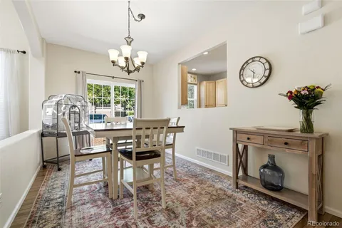 a view of a dining room with furniture a chandelier and wooden floor