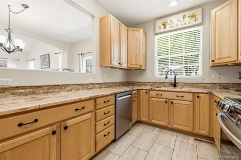 a kitchen with granite countertop cabinets stainless steel appliances a sink and a large window
