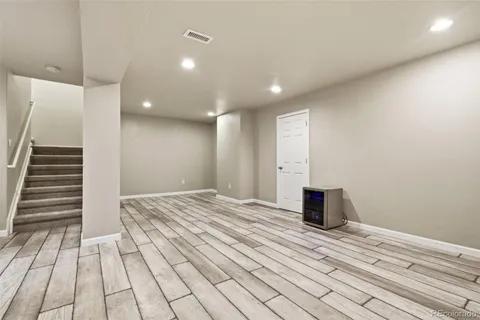 a view of a bedroom with wooden floor and stairs