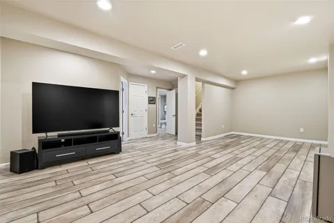 a view of a livingroom with wooden floor and a flat screen tv