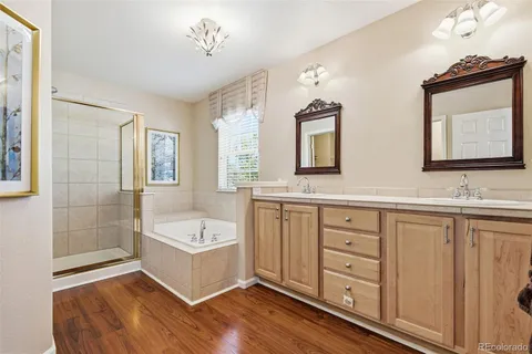 a spacious bathroom with a double vanity sink a mirror and a bathtub
