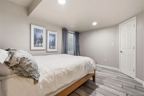 a bedroom with a large bed and wooden floor