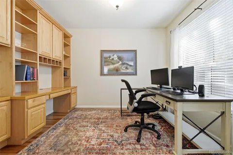 a view of a workspace with furniture and a window