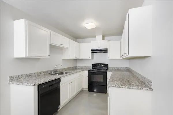 a kitchen with granite countertop white cabinets and stainless steel appliances