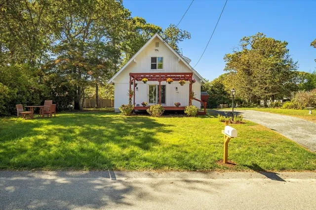 a front view of house with yard and trees in the background