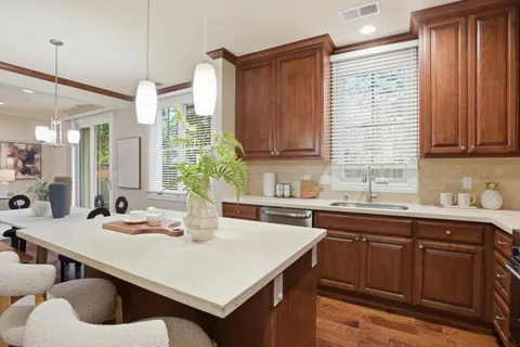 a kitchen with kitchen island granite countertop a sink a center island and cabinets
