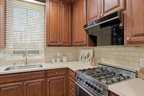a kitchen with wooden cabinets and a stove top oven