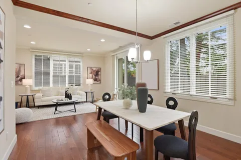 a view of a a dining room with furniture window and wooden floor