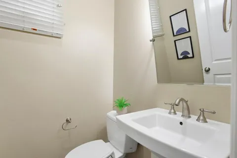 a bathroom with a sink mirror and toilet