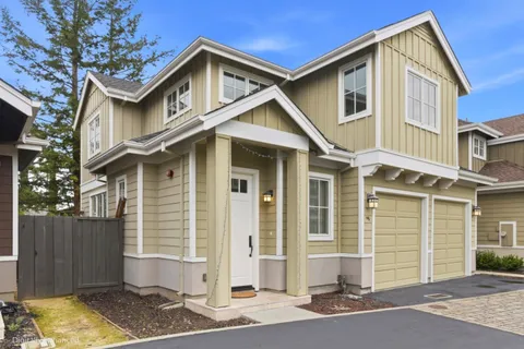 a front view of a house with a garden and garage