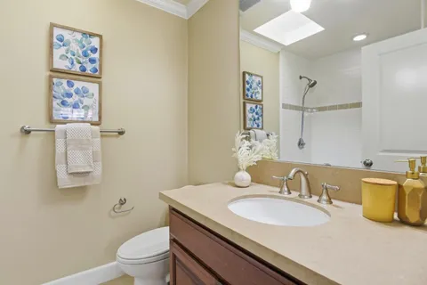a bathroom with a granite countertop sink a toilet and a mirror