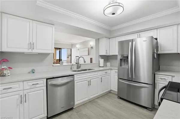 a kitchen with appliances a sink and lots of cabinets