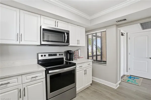 a kitchen with white cabinets stainless steel appliances and sink
