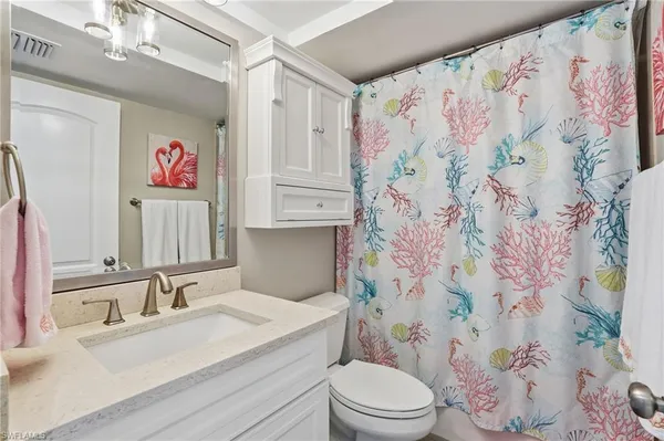 a bathroom with a sink a toilet and shower curtain