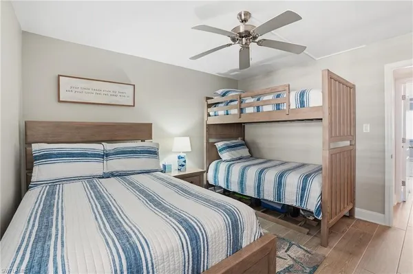 a bedroom with two beds and a ceiling fan