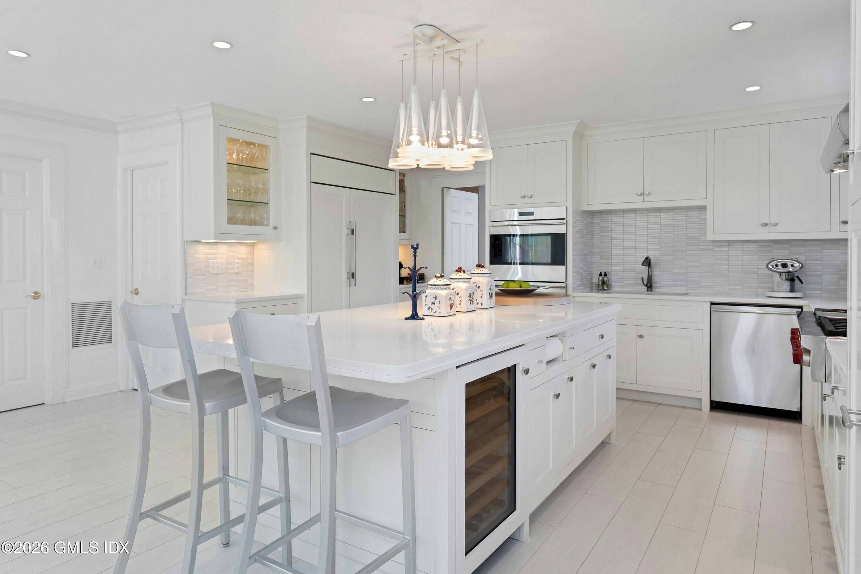 16 Summit Road Riverside, CT 06878 - Photo 7 of 34 a kitchen with stainless steel appliances a white stove top oven a sink dishwasher and a dining table with wooden floor