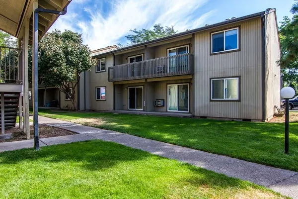 a view of a brick house with a yard