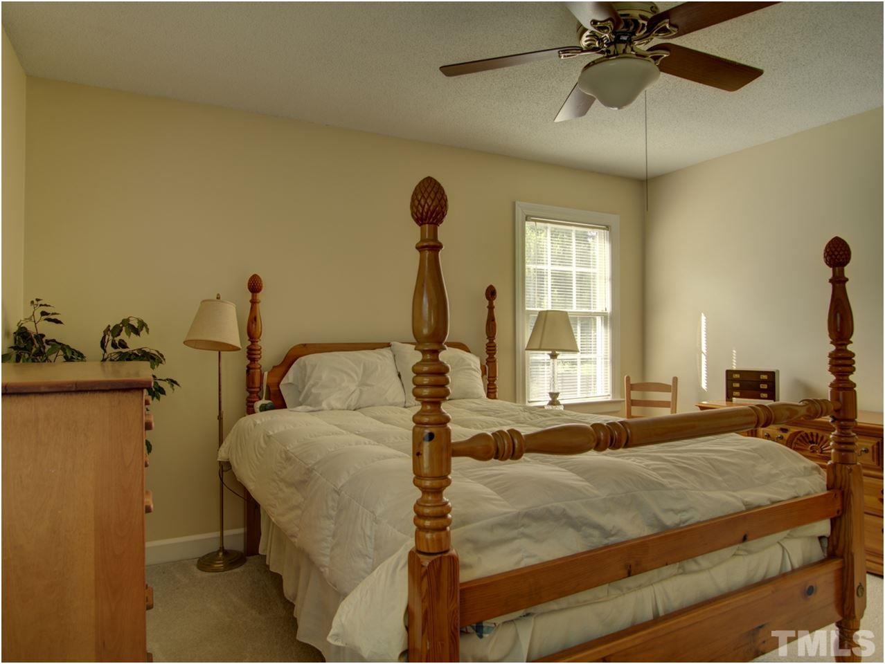 2016 Travianna Court Raleigh, NC 27609 - Photo 11 of 19 a bedroom with a bed and a chandelier