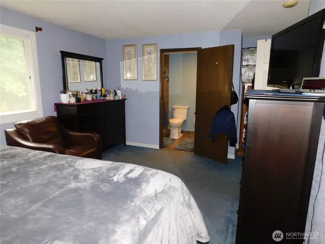 a bedroom with a bed and flat screen tv