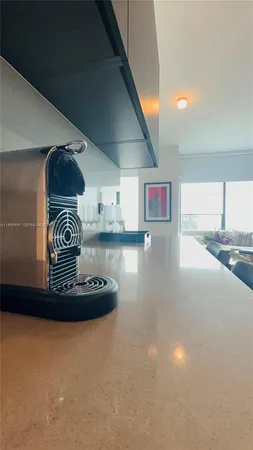 a view of kitchen with stainless steel appliances granite countertop tops and a view of living room