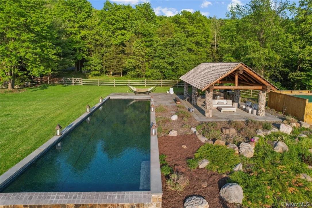101 Mountain Lodge Road Washingtonville, NY 10992 - Photo 20 of 26 a view of a backyard with table and chairs under an umbrella
