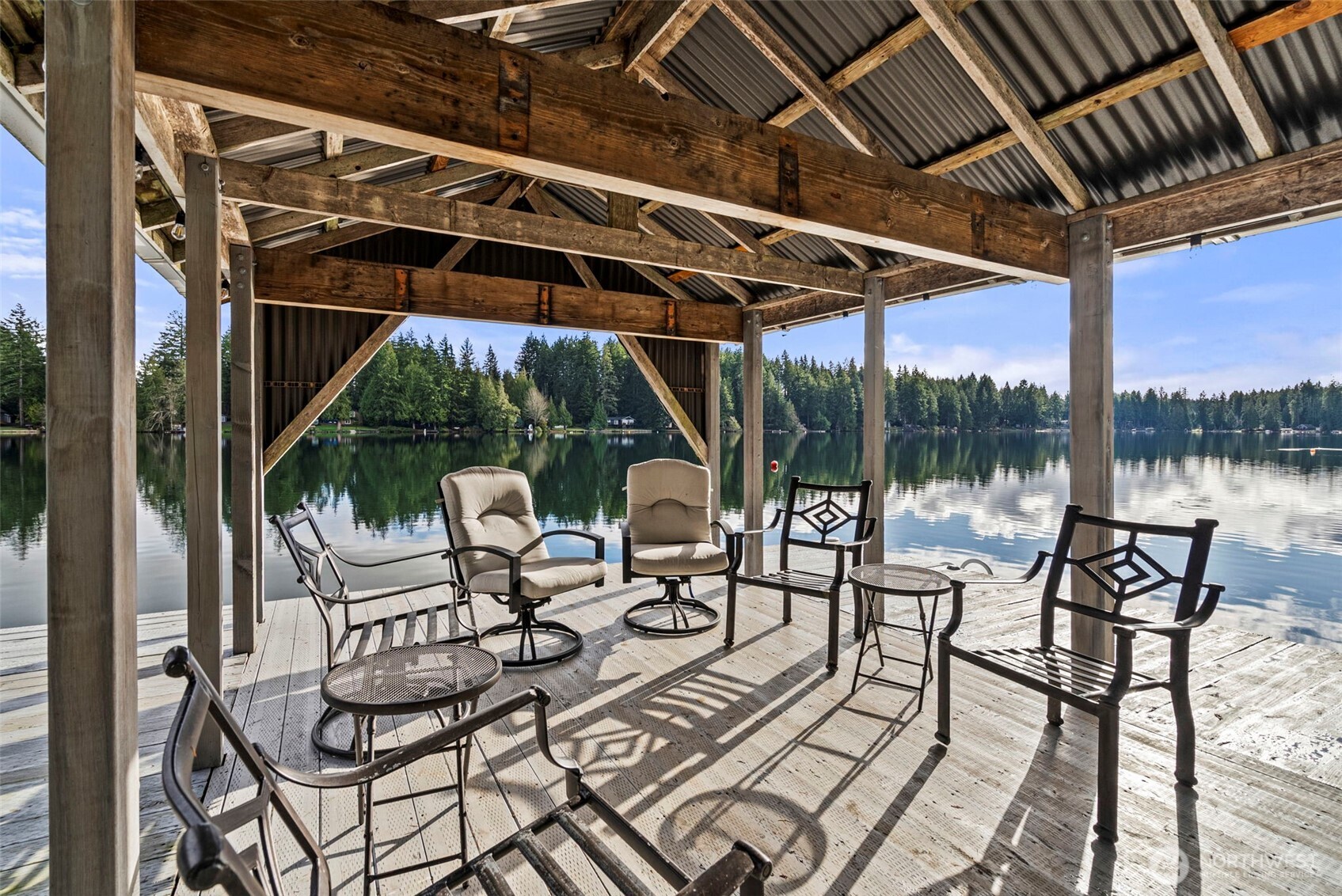 2800 East Phillips Lake Loop Road Shelton, WA 98584 - Photo 30 of 40 a view of a patio with table and chairs potted plants with floor to ceiling window and outdoor kitchen