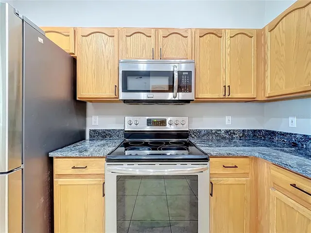 a view of an empty room with window and chandelier fan