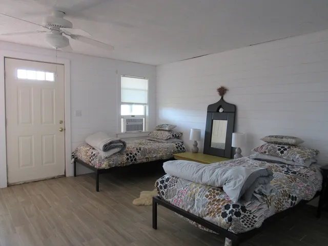 a bedroom with two beds and a dresser