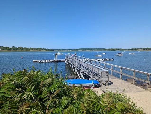 a view of a terrace with a bench and white umbrellas