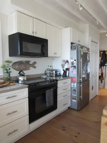 a kitchen with stainless steel appliances white cabinets white stove a sink and a refrigerator