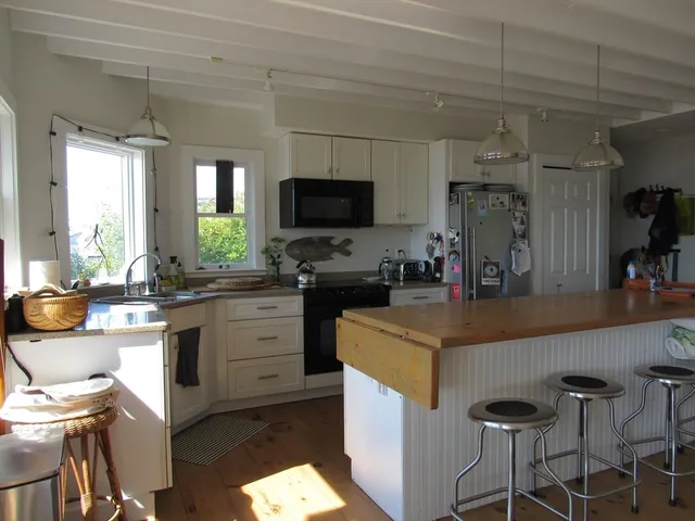 a kitchen with a sink a stove and chairs