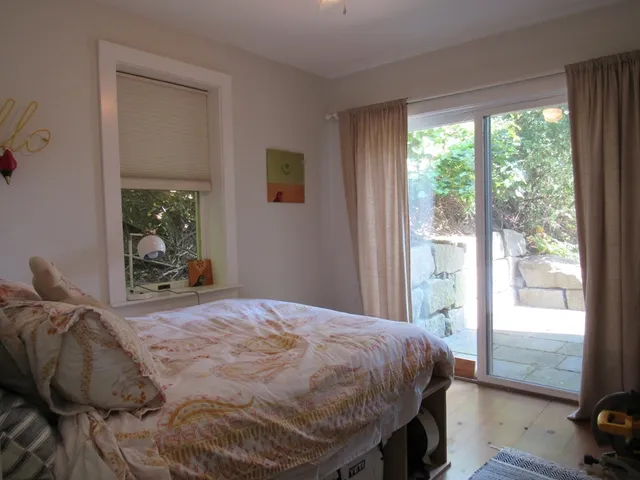 a bed sitting in a bedroom next to a window