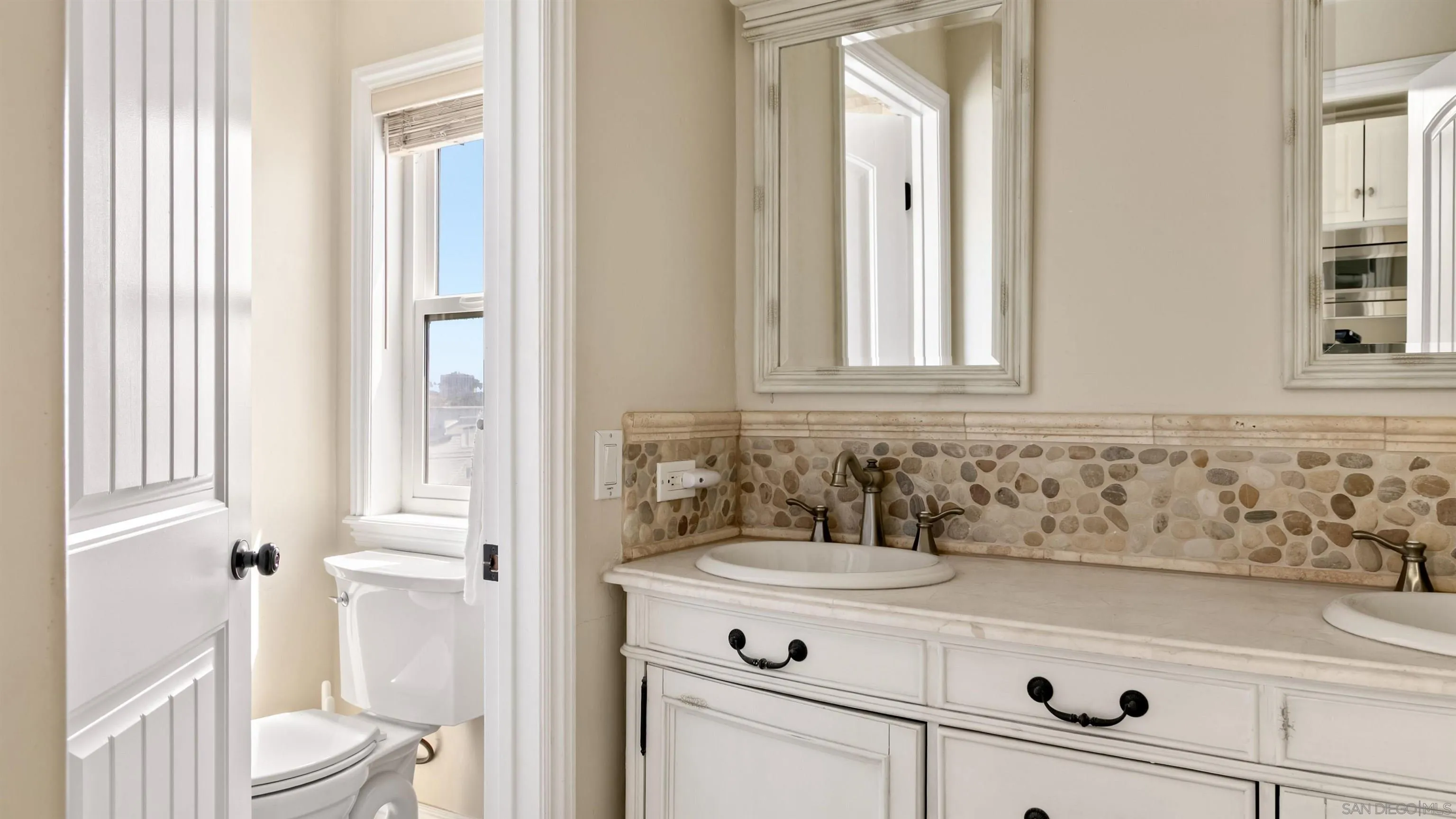 3285 Ocean Front Walk, Unit 3 San Diego, CA 92109 - Photo 24 of 38 a bathroom with a sink a toilet and a mirror