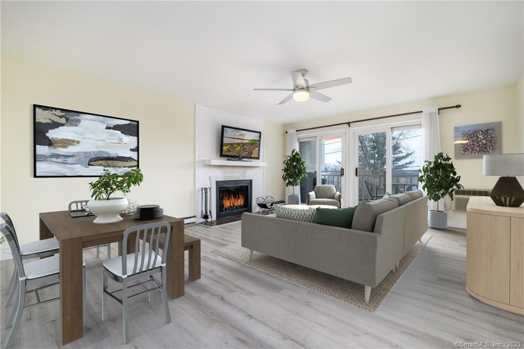 950 Cove Road, Unit B7 Stamford, CT 06902 - Photo 1 of 1 a living room with furniture a fireplace a flat screen tv and potted plant