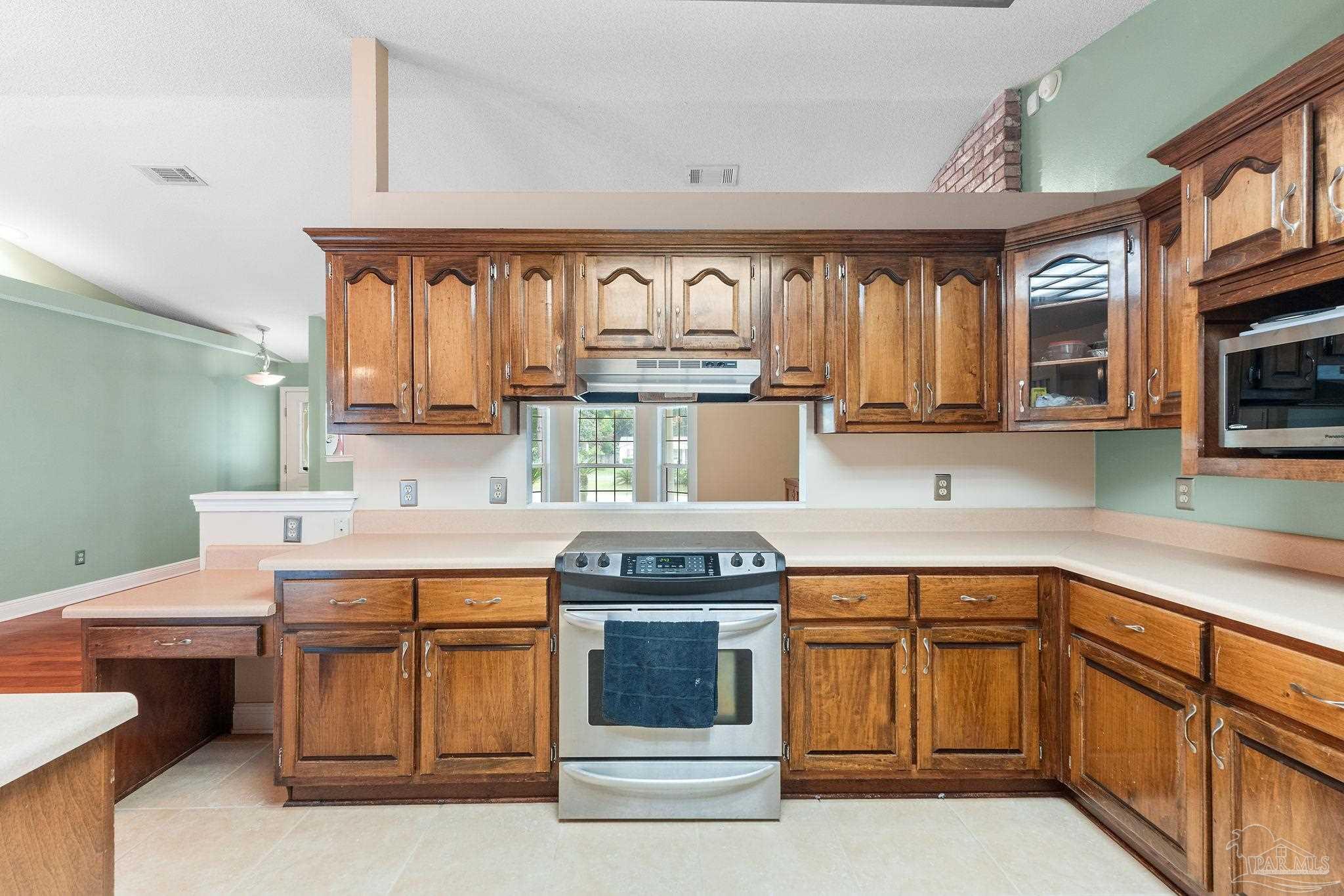 5645 Windham Road Milton, FL 32570 - Photo 13 of 40 a kitchen with stainless steel appliances granite countertop a stove a sink and a microwave