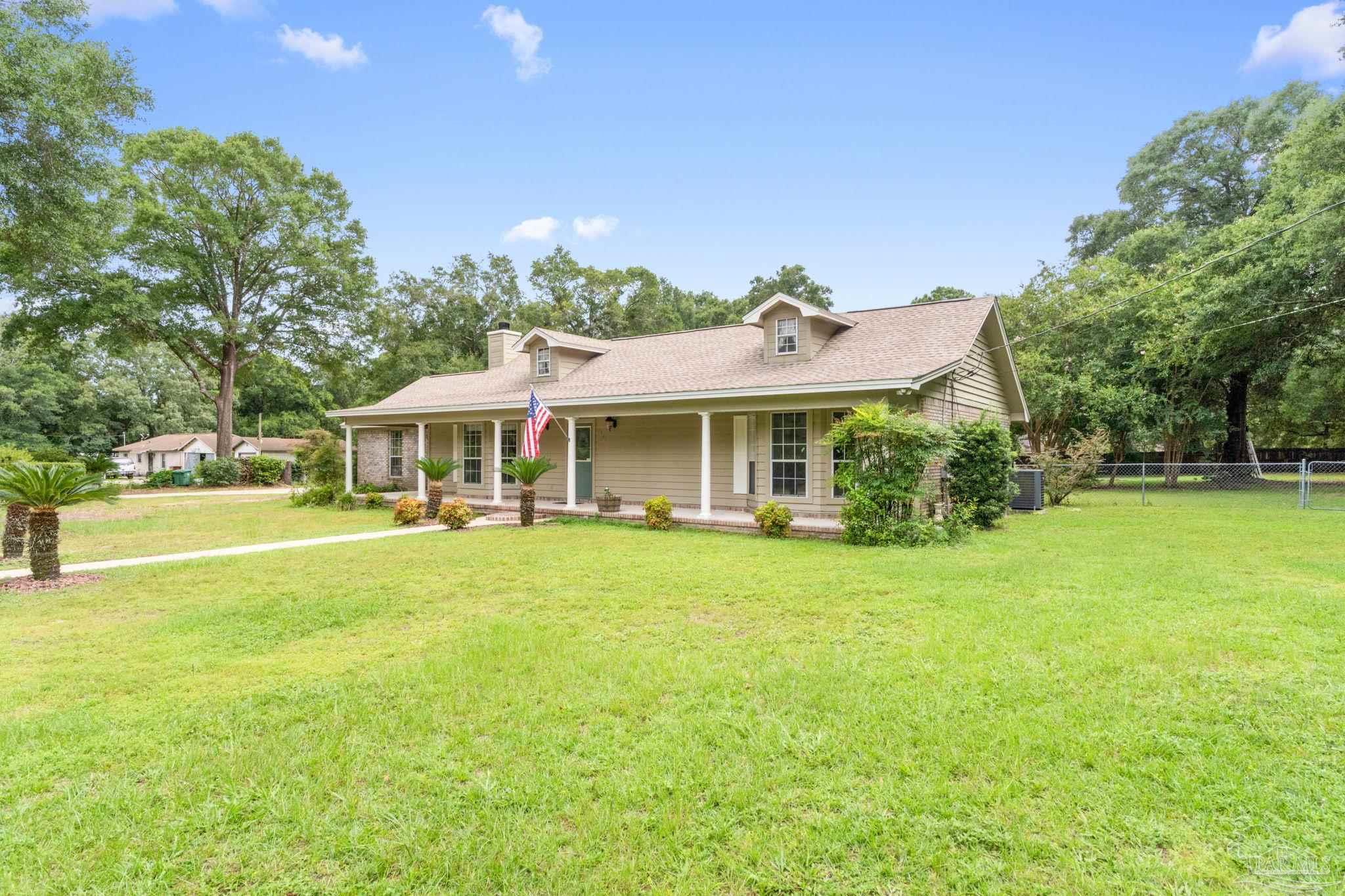 5645 Windham Road Milton, FL 32570 - Photo 2 of 40 a front view of a house with swimming pool having outdoor seating