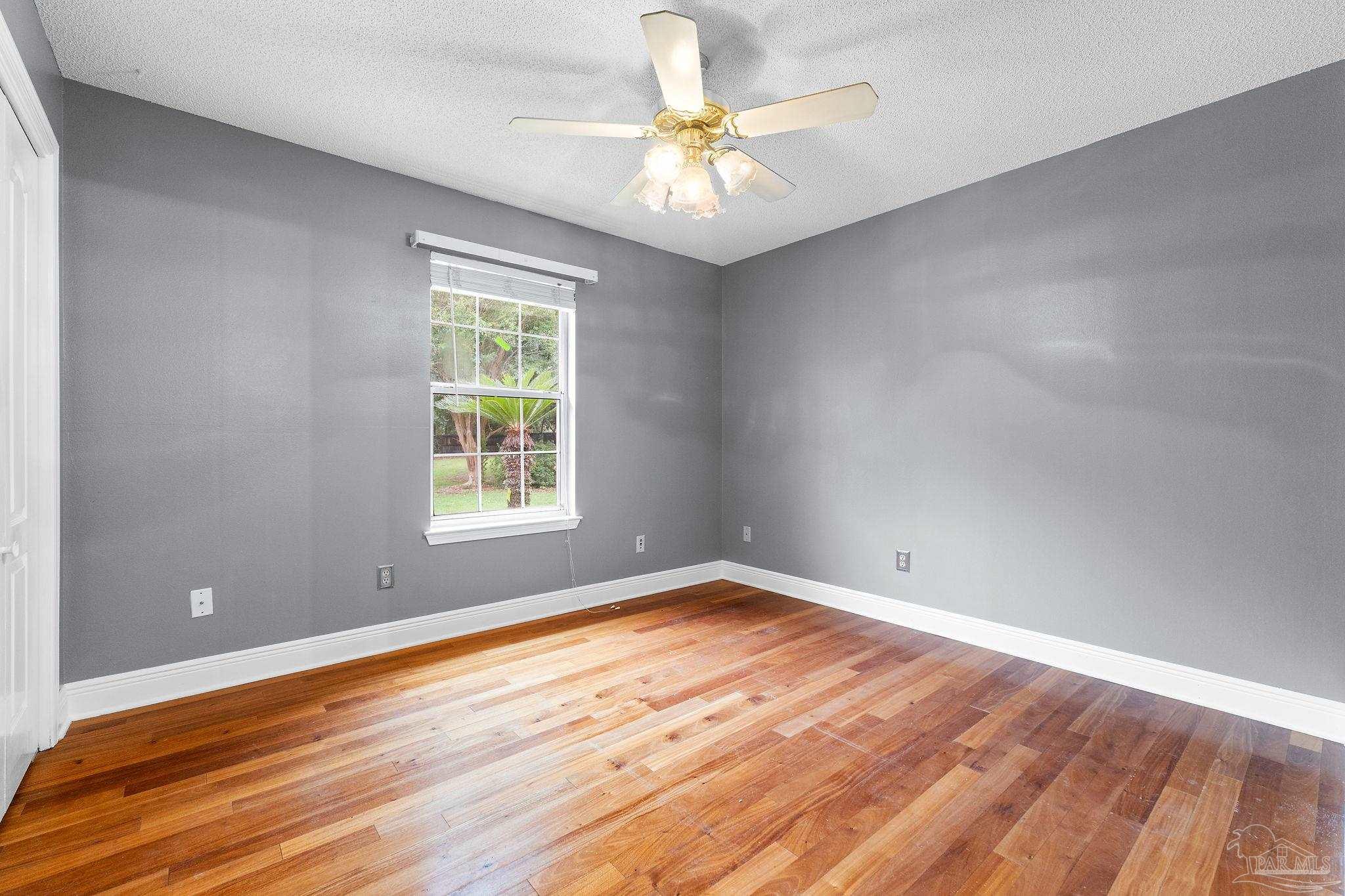 5645 Windham Road Milton, FL 32570 - Photo 22 of 40 a view of an empty room with window and wooden floor