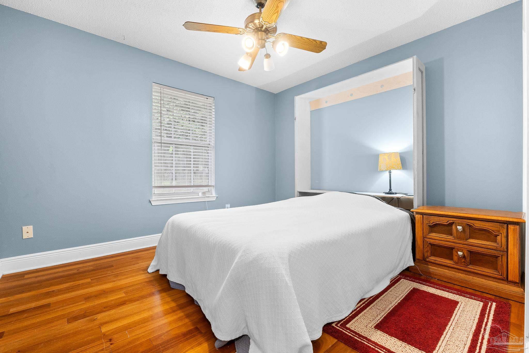 5645 Windham Road Milton, FL 32570 - Photo 24 of 40 a bedroom with a bed and a chandelier